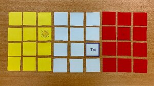 Ein Beispielbild für das Spiel "Trimory": Jeweils 12 umgedrehte Karten in gelb, weiß und rot liegen auf einem Tisch, drei Karten sind aufgedeckt.