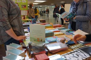 Mehrere Personen an einem Büchertisch