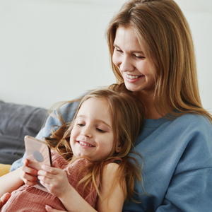 Mutter und Kind lesen am Smartphone