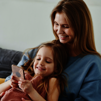 Mutter und Kind lesen am Smartphone